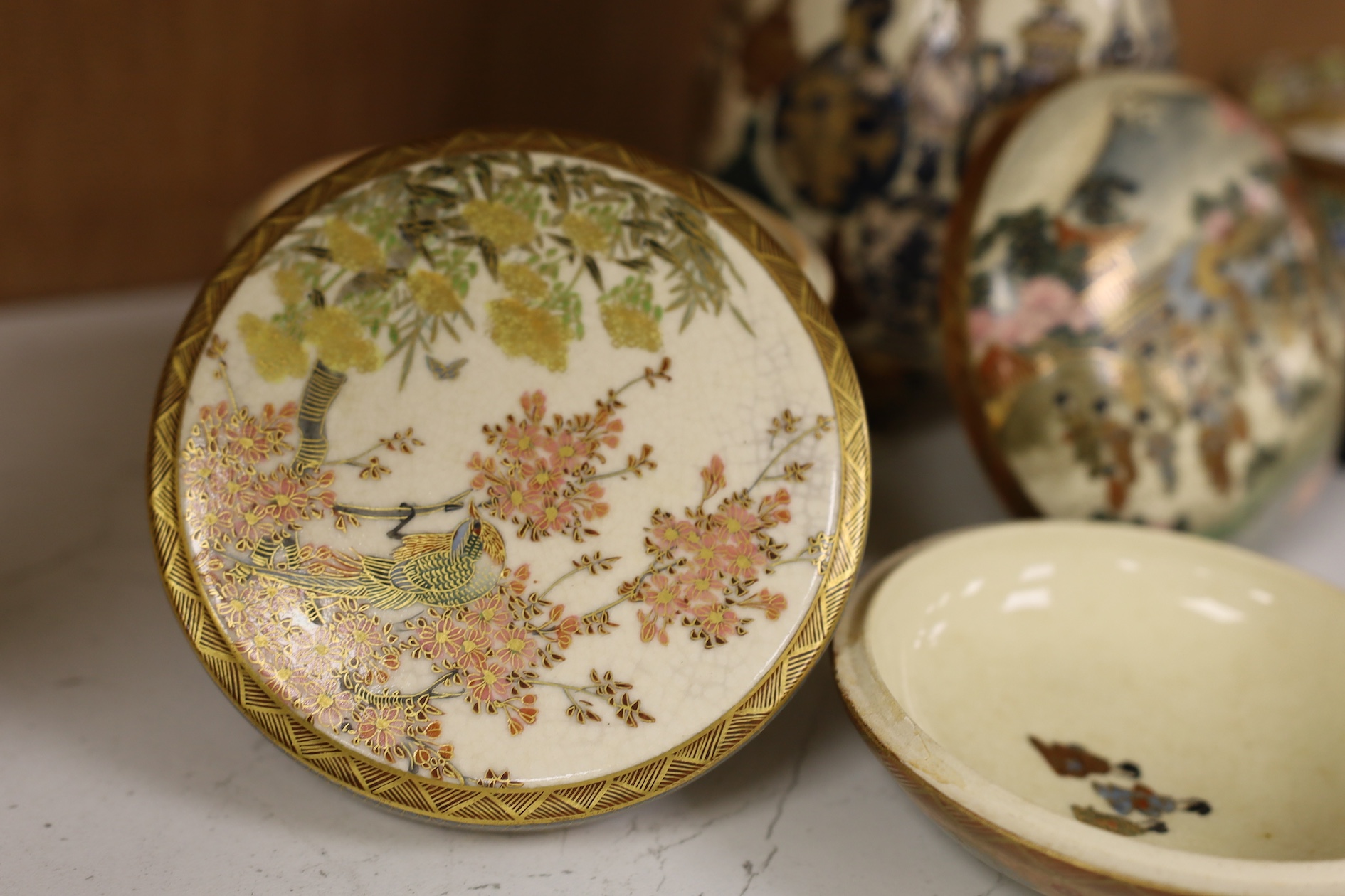 A late 19th century Japanese Satsuma ‘hundred antiques’ gosu blue pot pourri vase and three later items of Satsuma, including a bowl and cover a bowl on stand, a box and cover, tallest 18.5cm high. Condition - vase cover